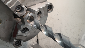 Image of hex stock being bored on an engine lathe.