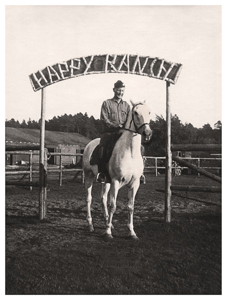A restored image of my grandfather sitting astride a horse in front of a ranch sign identifying the location as Happy Ranch.